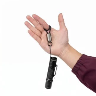 Small black flashlight attached to a lanyard and key ring, held in an open hand against a white background.
