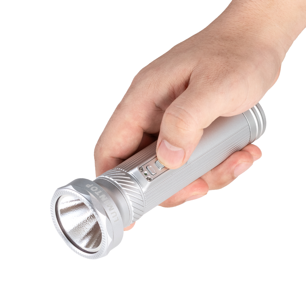 Hand gripping a small silver flashlight with a textured barrel and LED head facing forward.
